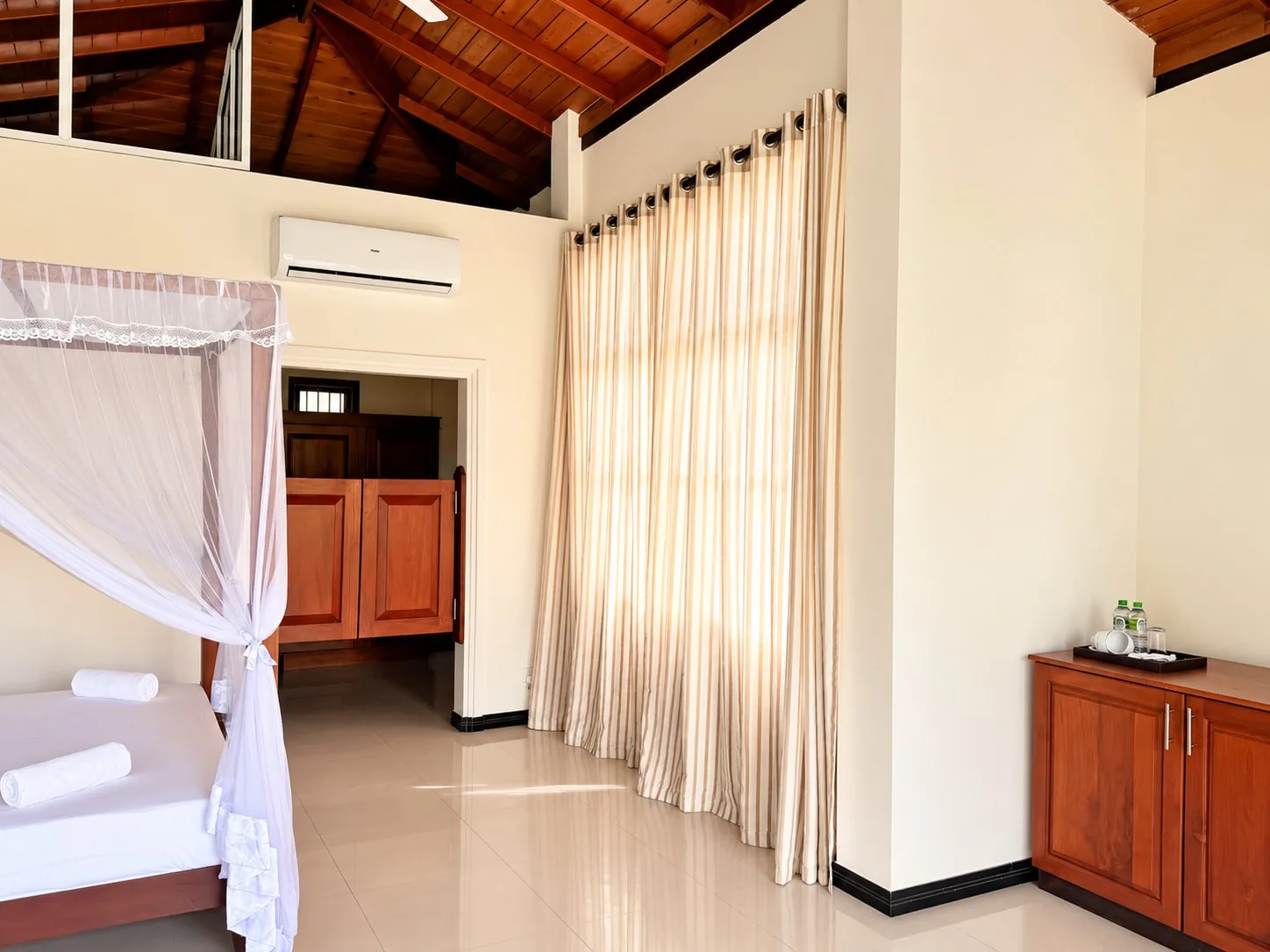 Estuary Suite — interior with full-height curtains and vaulted ceiling